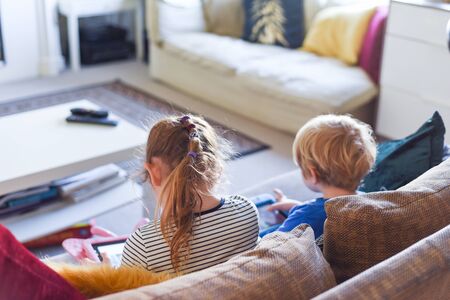 Children using their tablet device to play computer games and use educational appsの写真素材