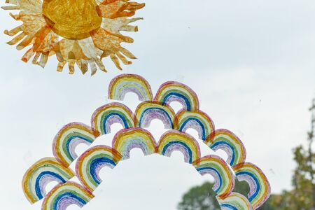 Kids drawings of rainbows in a window during covid-19 lockdown in ukの写真素材