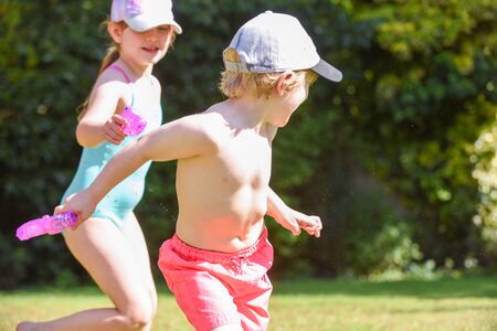 Kids playing with water in a garden on a sunny summer dayの写真素材