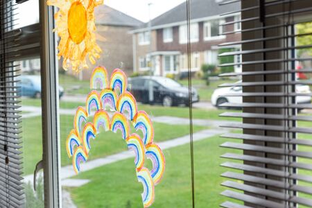 Kids drawings of rainbows in a window during covid-19 lockdown in ukの写真素材