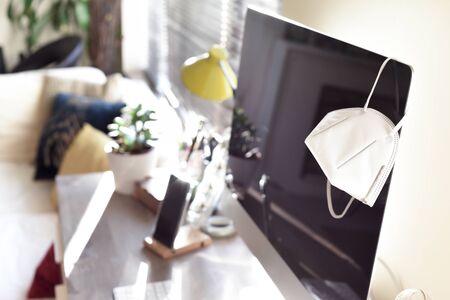 Home office with face mask representing work  from home during period of isolation and social distancingの写真素材
