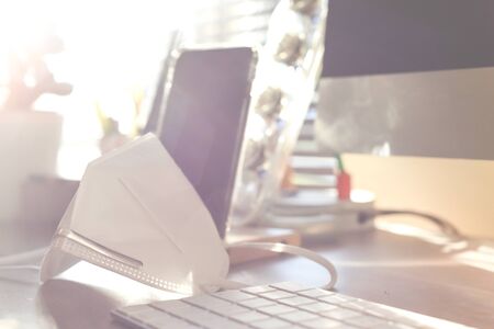 Home office with face mask representing work  from home during period of isolation and social distancingの写真素材