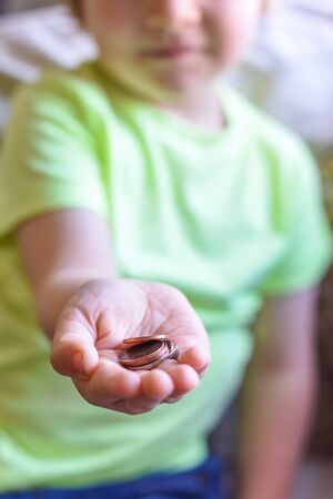 Child holding money in hand cash is UK currency coinsの写真素材
