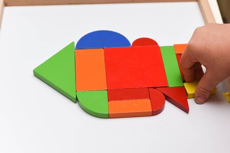 Child playing with colourful puzzle toy making shapes to learn at homeの写真素材