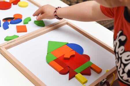 Child playing with colourful puzzle toy making shapes to learn at homeの写真素材
