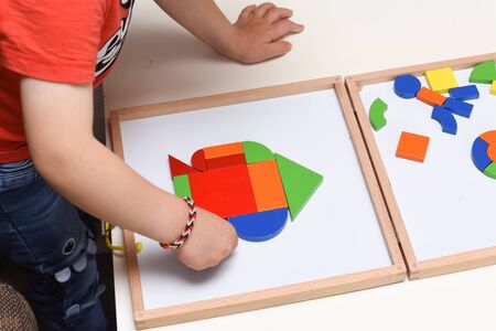 Child playing with colourful puzzle toy making shapes to learn at homeの写真素材