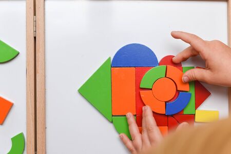 Child playing with colourful puzzle toy making shapes to learn at homeの写真素材