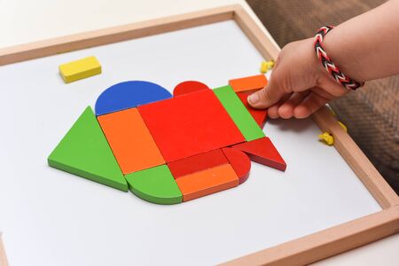 Child playing with colourful puzzle toy making shapes to learn at homeの写真素材
