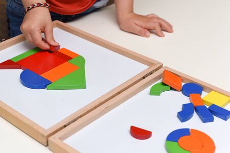 Child playing with colourful puzzle toy making shapes to learn at homeの写真素材