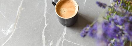 Coffee drink and flowers on a marble table in home interiorの写真素材