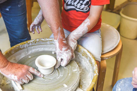 Children making pottery during ceramic lesson with clayの写真素材