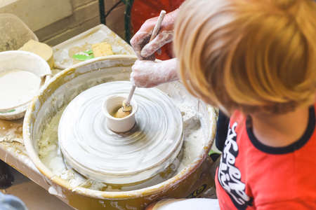 Children making pottery during ceramic lesson with clayの写真素材