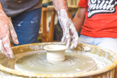 Children making pottery during ceramic lesson with clayの写真素材