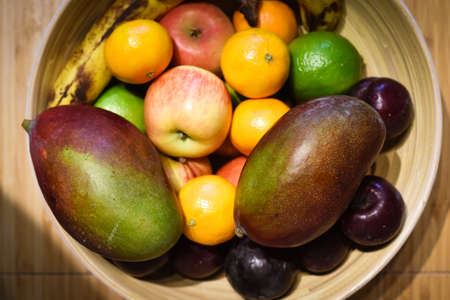 Healthy selection of fruit in a bowl on a kitchen tableの写真素材