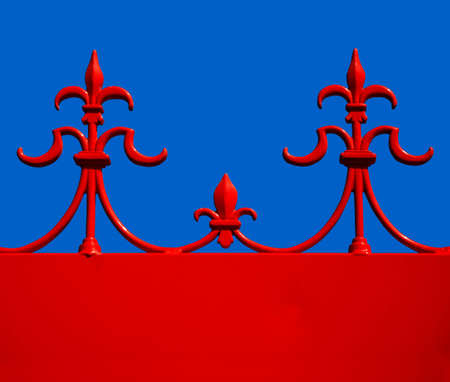 Red wrought iron decoration on old Victorian buidling, against a blue skyの写真素材