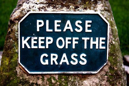 Please keep off the grass sign on a moss covered stone. Either literal or drugs metaphor.の写真素材