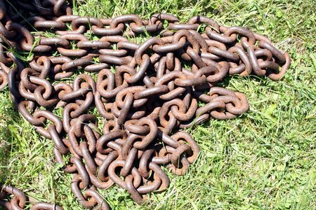 Rusty chain on grassy backgroundの写真素材