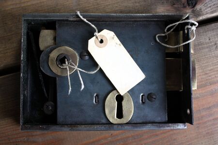 Old fashined door lock and tag label on locksmith's workbenchの写真素材