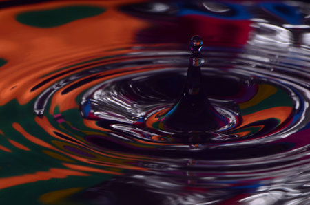 Droplet Splash Into Silver,Orange And Green Waterの写真素材