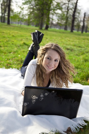 Young woman in park with laptop の写真素材