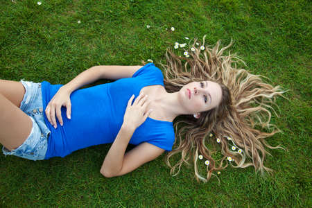 Young beautiful woman lying in parkの写真素材