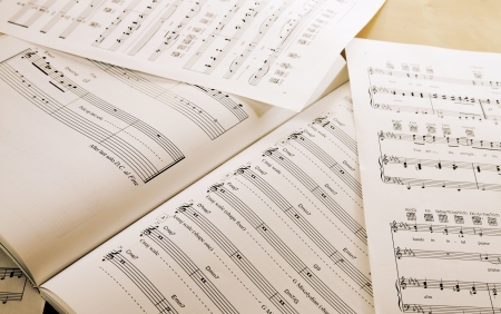 Book and papers with music notes on tableの写真素材