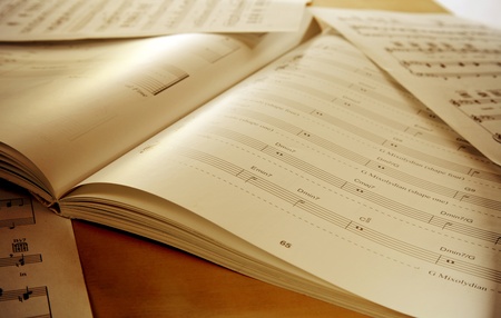 Book and papers with music notes on tableの写真素材