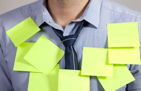 Businessman with plenty of post it notesの写真素材
