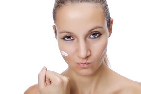 Beautiful girl fed up with applying moisturizing creamの写真素材