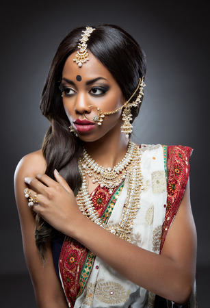 Young Indian woman dressed in traditional clothing with bridal makeup and jewelryの写真素材