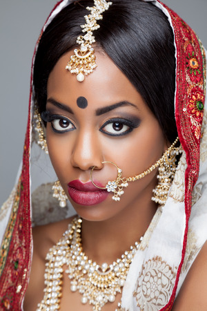 Young Indian woman dressed in traditional clothing with bridal makeup and jewelryの写真素材