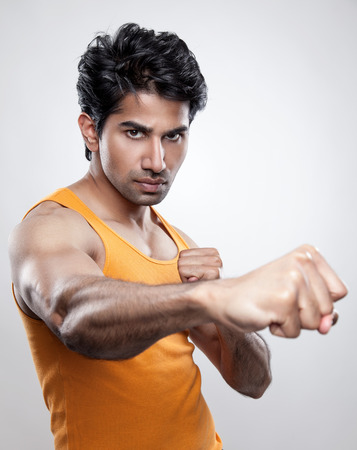 Handsome Indian man giving a knockout punchの写真素材