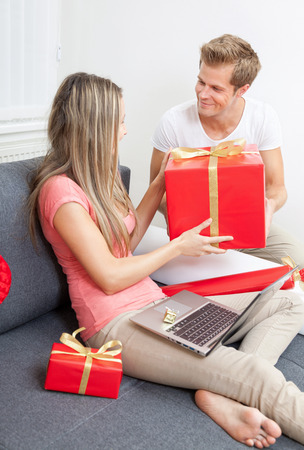Happy couple exchanging gifts for the special occasion の写真素材