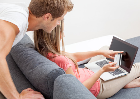 Happy couple shopping online from the comfort of their homeの写真素材