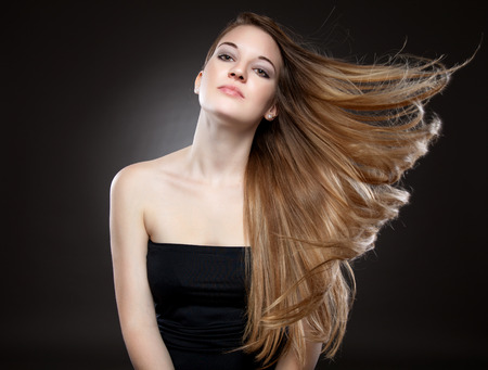 Beautiful woman with strong long brown hairの写真素材