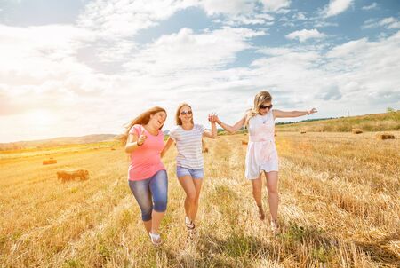 Three best friends having fun outdoors on a sunny dayの写真素材
