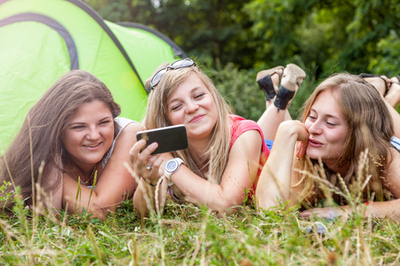 Group of friends having fun outdoors with a smart phoneの写真素材