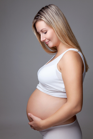 Portrait of a pregnant woman holding her bellyの写真素材