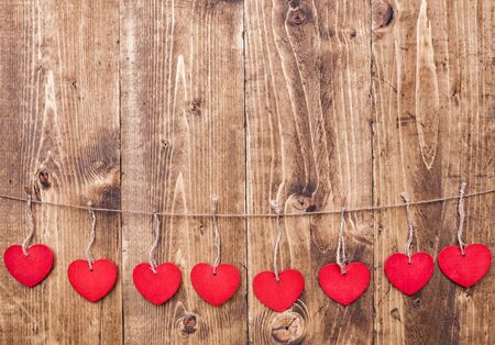 Love concept. Hearts hanging on a string, shot on wooden backgroundの写真素材