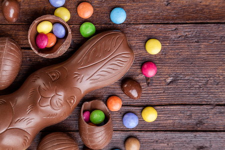Delicious chocolate easter eggs and sweets on wooden backgroundの写真素材