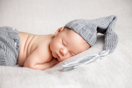 Beautiful newborn baby sleeping on a blanketの写真素材