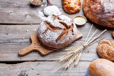 Delicious freshly baked bread on wooden background