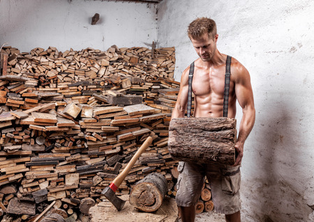 Shirtless handsome and muscular lumberjack with an axeの写真素材