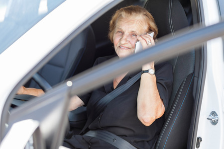 Elderly woman behind the steering wheel of a carの写真素材