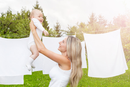 Beautiful mother and her baby boy playing together outdoorsの写真素材