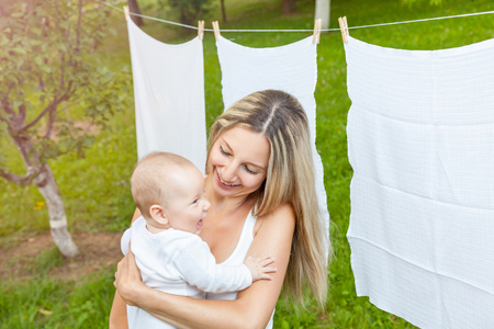 Beautiful mother and her baby boy playing together outdoorsの写真素材