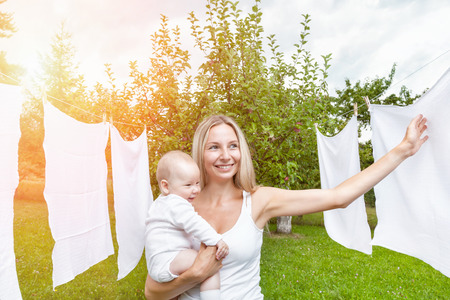 Beautiful mother and her baby boy playing together outdoorsの写真素材