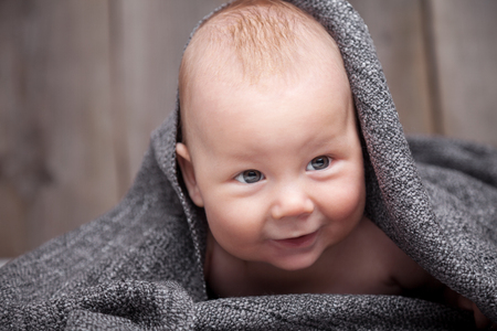 Beautiful newborn baby wrapped in a blanketの写真素材