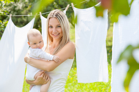 Beautiful mother and her baby boy playing together outdoorsの写真素材