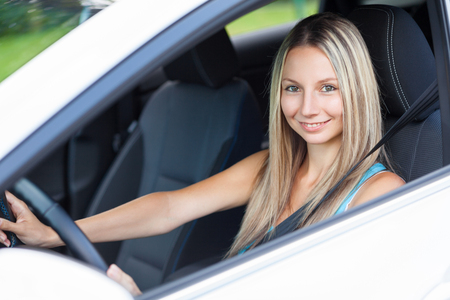 Young woman behind the steering wheel of a carの写真素材